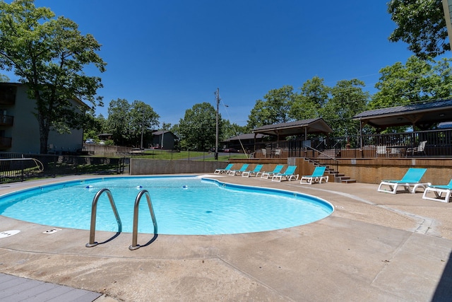 pool with fence and a patio area