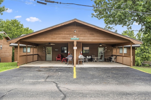 view of front facade with a ceiling fan, aphalt driveway, and an attached carport