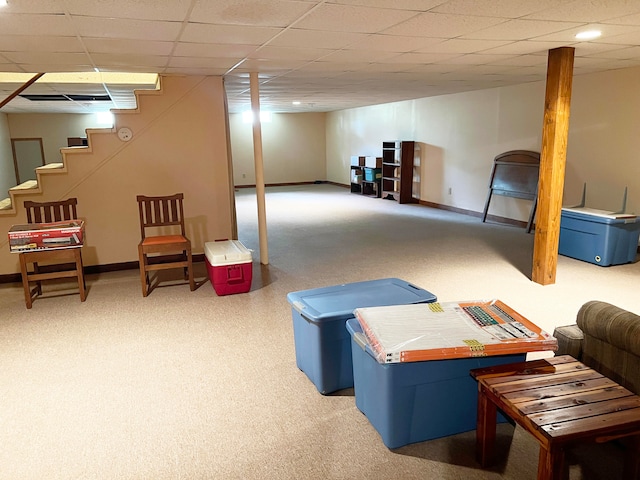 basement featuring a paneled ceiling and carpet flooring