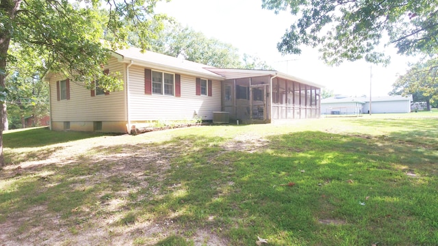 rear view of property with a sunroom and a lawn