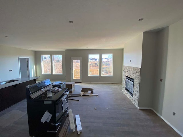 unfurnished living room featuring a fireplace, dark hardwood / wood-style floors, and a wealth of natural light