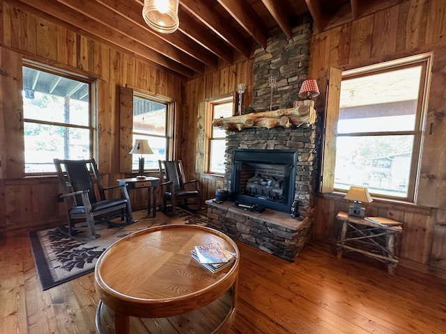 living area with hardwood / wood-style flooring, beamed ceiling, and wood walls