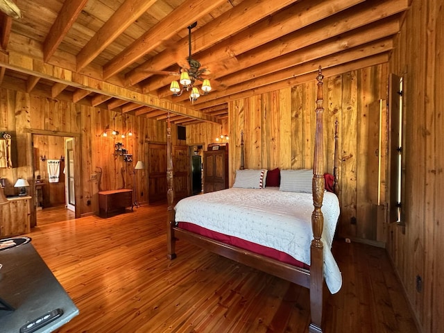 bedroom with hardwood / wood-style floors, wooden walls, and beam ceiling