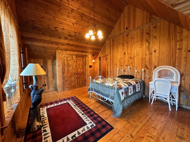 bedroom with wood walls, wood-type flooring, wooden ceiling, and a chandelier