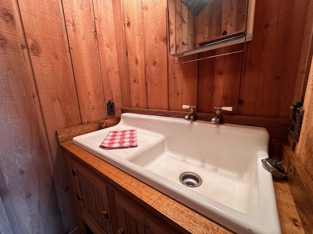 bathroom with sink and wooden walls