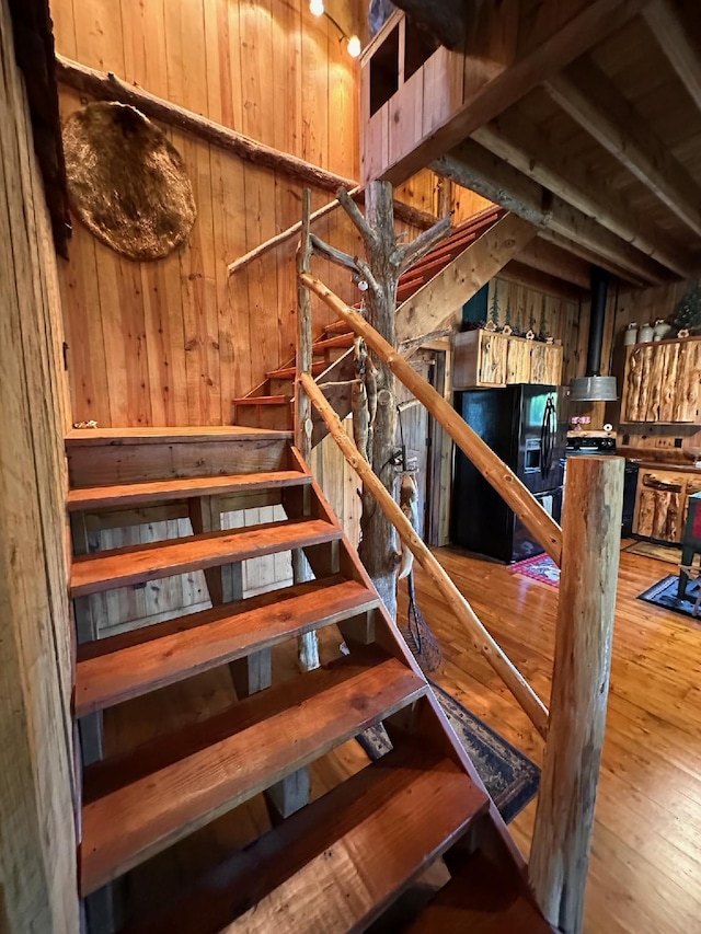 stairway with wood-type flooring and wooden walls