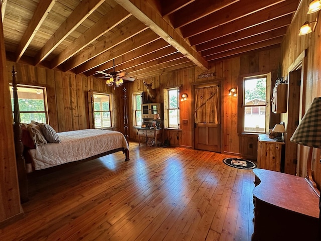 bedroom featuring hardwood / wood-style flooring, wood ceiling, wood walls, and beam ceiling