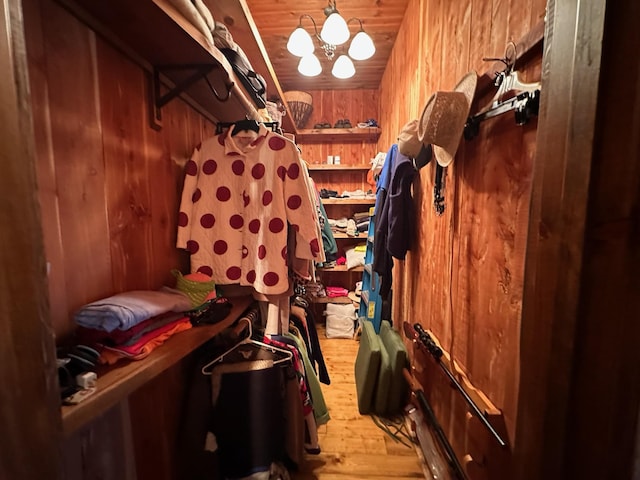 spacious closet with a notable chandelier and light hardwood / wood-style flooring