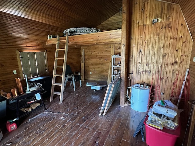 unfurnished bedroom with wooden walls, wood ceiling, hardwood / wood-style floors, and lofted ceiling