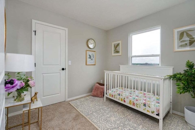 bedroom with a nursery area and carpet flooring