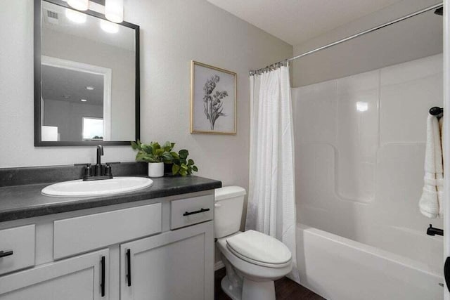 full bathroom featuring shower / tub combo with curtain, vanity, and toilet