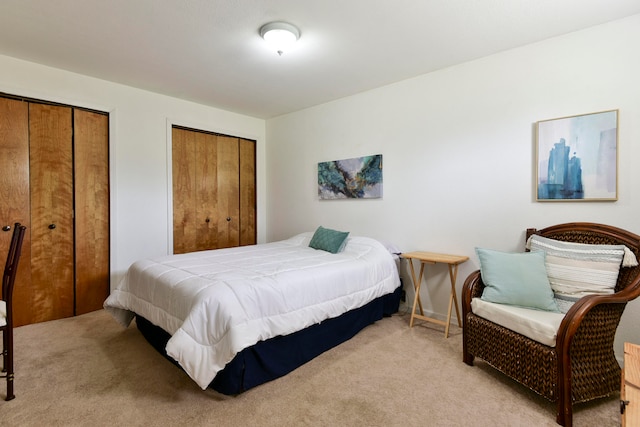 carpeted bedroom featuring two closets