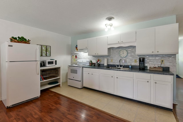 kitchen with sink, white cabinetry, light hardwood / wood-style flooring, and white appliances