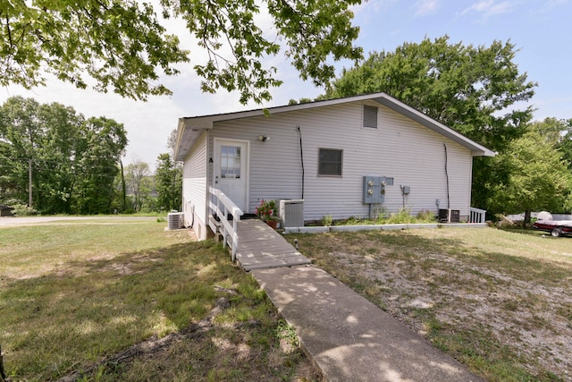 view of front of home featuring central air condition unit and a front yard