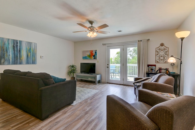 living room with light hardwood / wood-style floors and ceiling fan