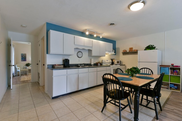 kitchen with white cabinets, light hardwood / wood-style floors, sink, ventilation hood, and white appliances