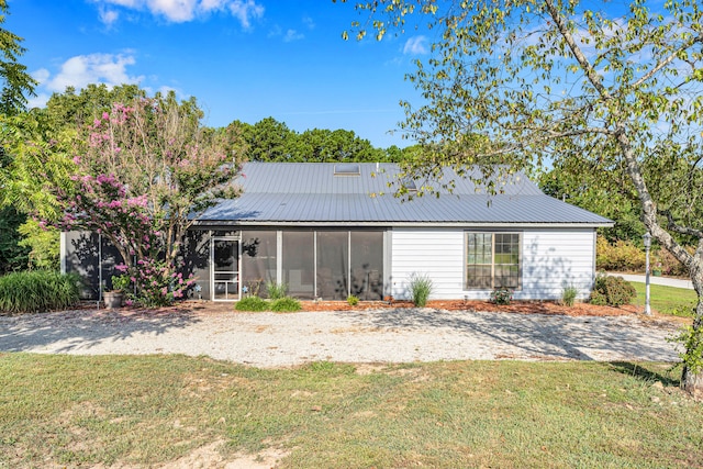 back of house with a yard and a sunroom