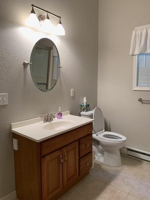 43 Dale Dr, Kimberling City, MO 65686 - bathroom with a baseboard heating unit, tile patterned floors, vanity, and toilet