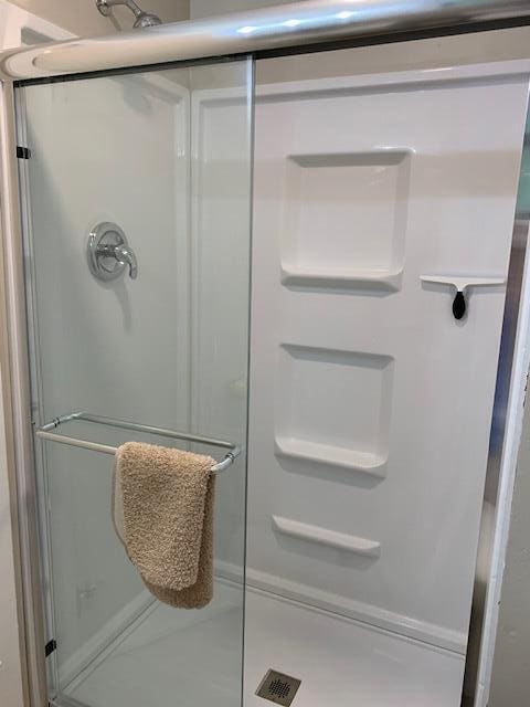 bathroom with a shower with door