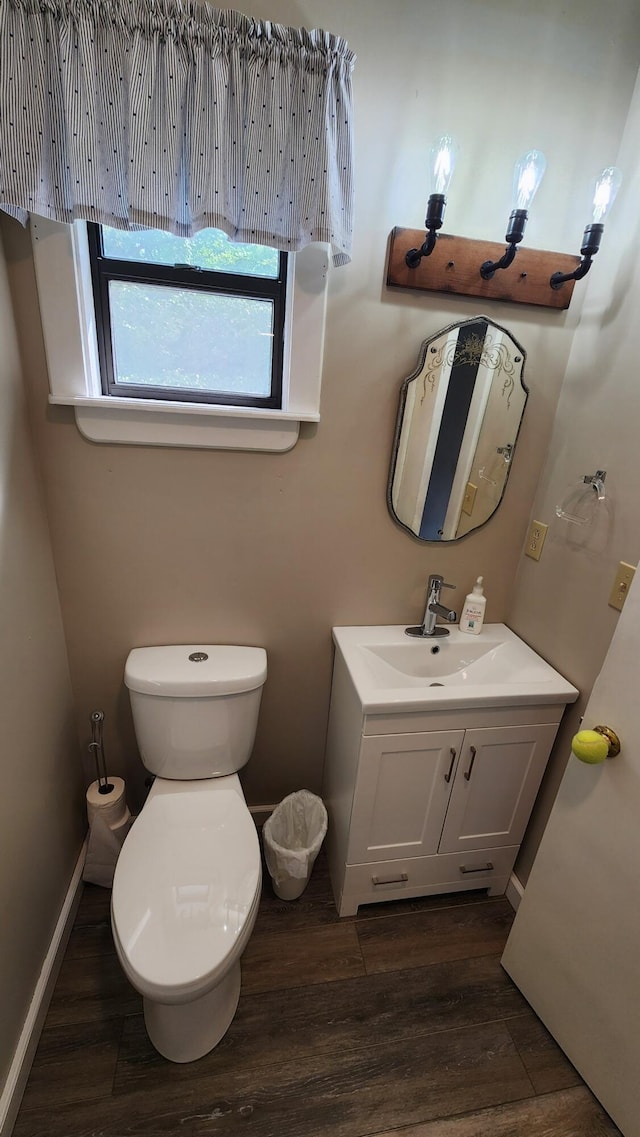 bathroom featuring wood-type flooring, vanity, and toilet