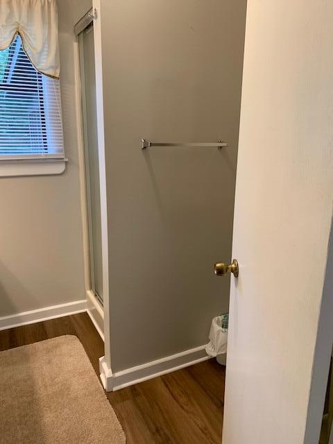 bathroom with hardwood / wood-style flooring and a shower with door