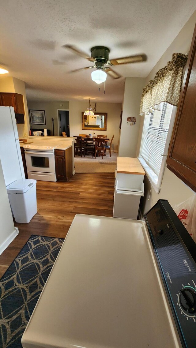 kitchen featuring ceiling fan, white appliances, a textured ceiling, dark hardwood / wood-style flooring, and wood counters