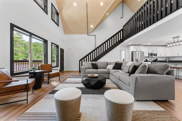 living room featuring wooden ceiling, high vaulted ceiling, and light wood-type flooring