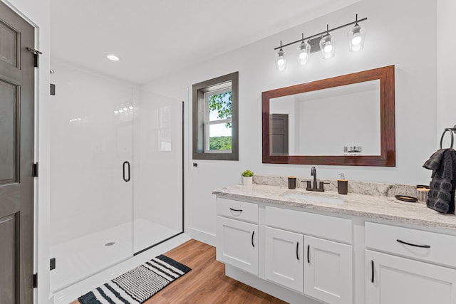 bathroom featuring vanity, a shower with door, and hardwood / wood-style flooring