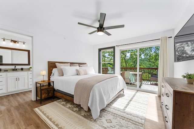 bedroom featuring light wood-type flooring, ceiling fan, sink, connected bathroom, and access to outside