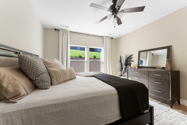 bedroom featuring ceiling fan, visible vents, light wood-style flooring, and baseboards