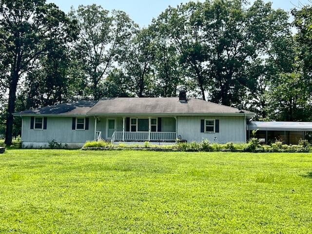 ranch-style home with covered porch and a front yard