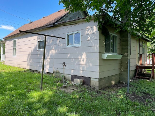 view of side of home featuring a deck and a lawn