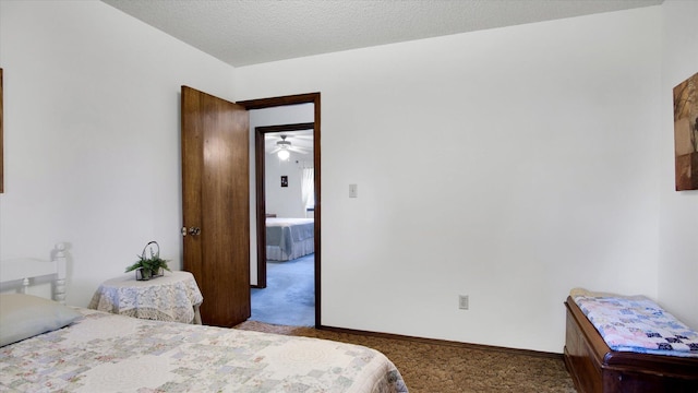 bedroom featuring a textured ceiling, carpet flooring, and baseboards