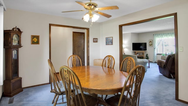 dining area featuring carpet, a ceiling fan, and baseboards