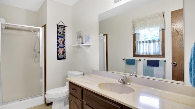 bathroom with toilet, a shower stall, and vanity