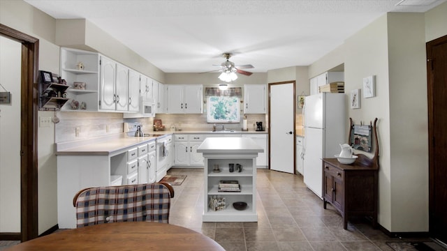 kitchen featuring white appliances, white cabinets, light countertops, backsplash, and open shelves