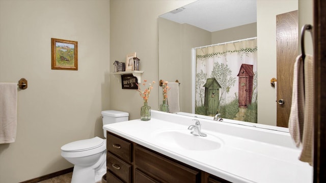 bathroom with toilet, vanity, and baseboards