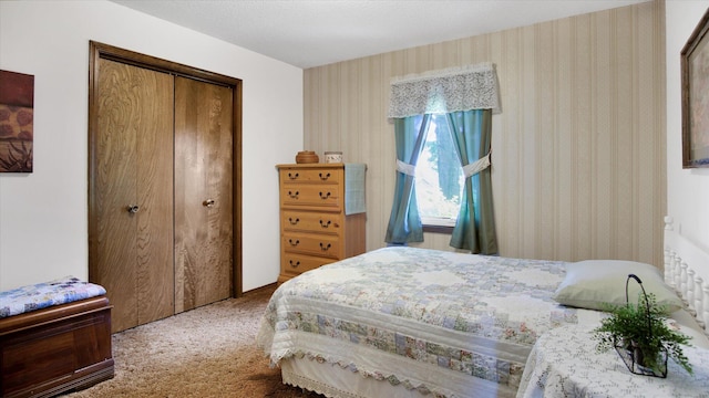 carpeted bedroom with a closet and wallpapered walls