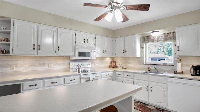 kitchen featuring white appliances, white cabinetry, and a sink