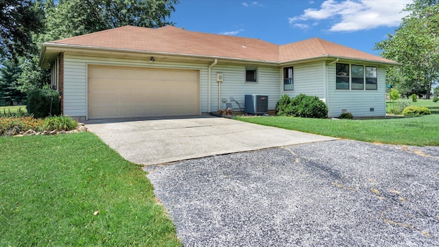 ranch-style home featuring a front yard, cooling unit, and a garage