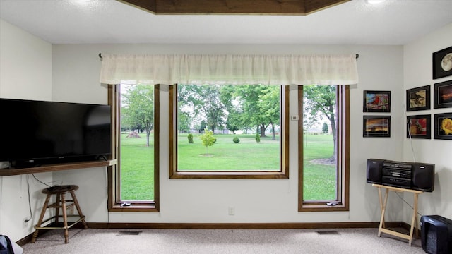 unfurnished living room with a healthy amount of sunlight, visible vents, and carpet flooring