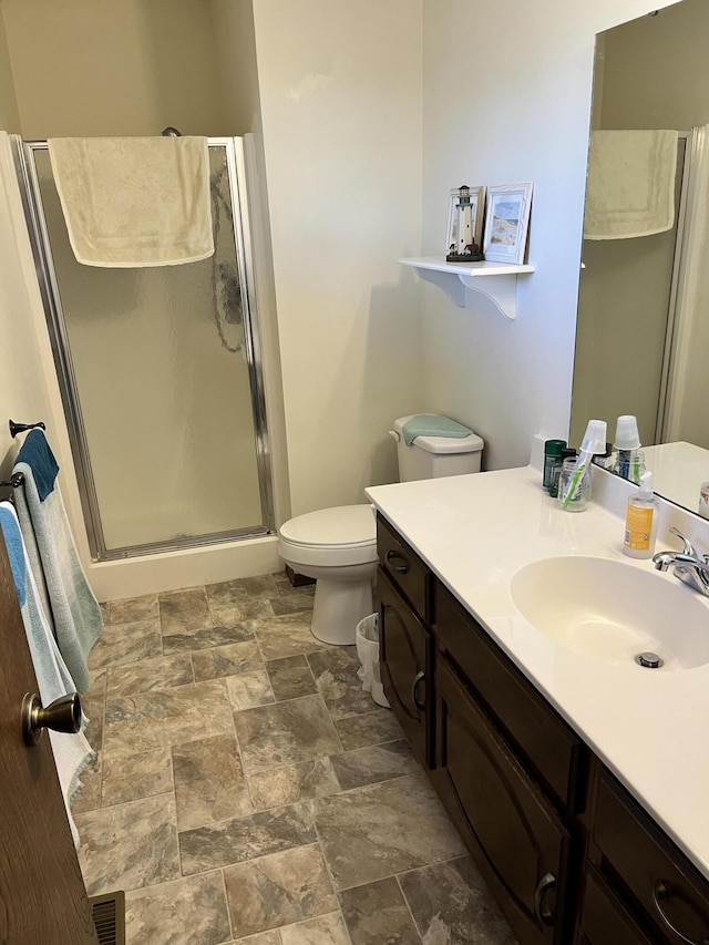 full bath with visible vents, toilet, stone finish floor, vanity, and a shower stall