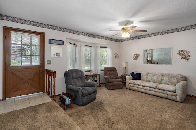 carpeted living room featuring ceiling fan and a textured ceiling