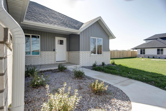 3668 W Overland St, Springfield, MO 65807 - view of exterior entry with a shingled roof, brick siding, and board and batten siding