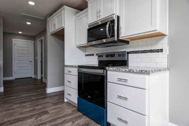 kitchen with light stone counters, appliances with stainless steel finishes, backsplash, white cabinets, and dark wood-type flooring