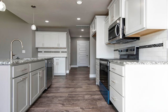 kitchen with white cabinets, appliances with stainless steel finishes, dark wood-type flooring, and hanging light fixtures