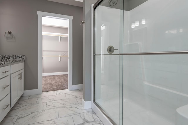 3668 W Overland St, Springfield, MO 65807 - full bathroom featuring a stall shower, a spacious closet, vanity, baseboards, and marble look tile flooring