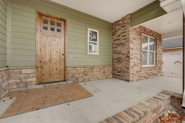 view of exterior entry with covered porch