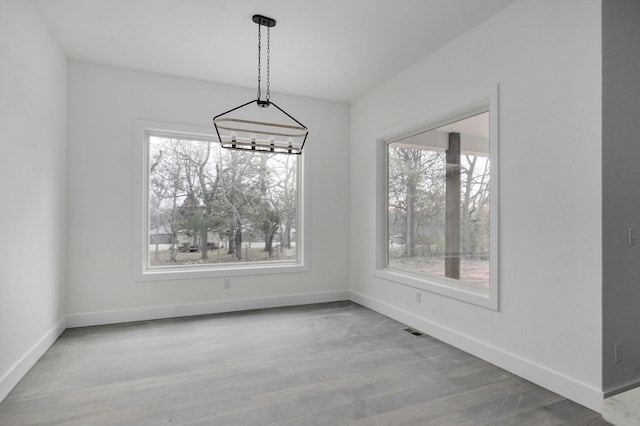 unfurnished dining area featuring light wood-type flooring