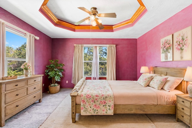 bedroom featuring a tray ceiling, ceiling fan, and crown molding